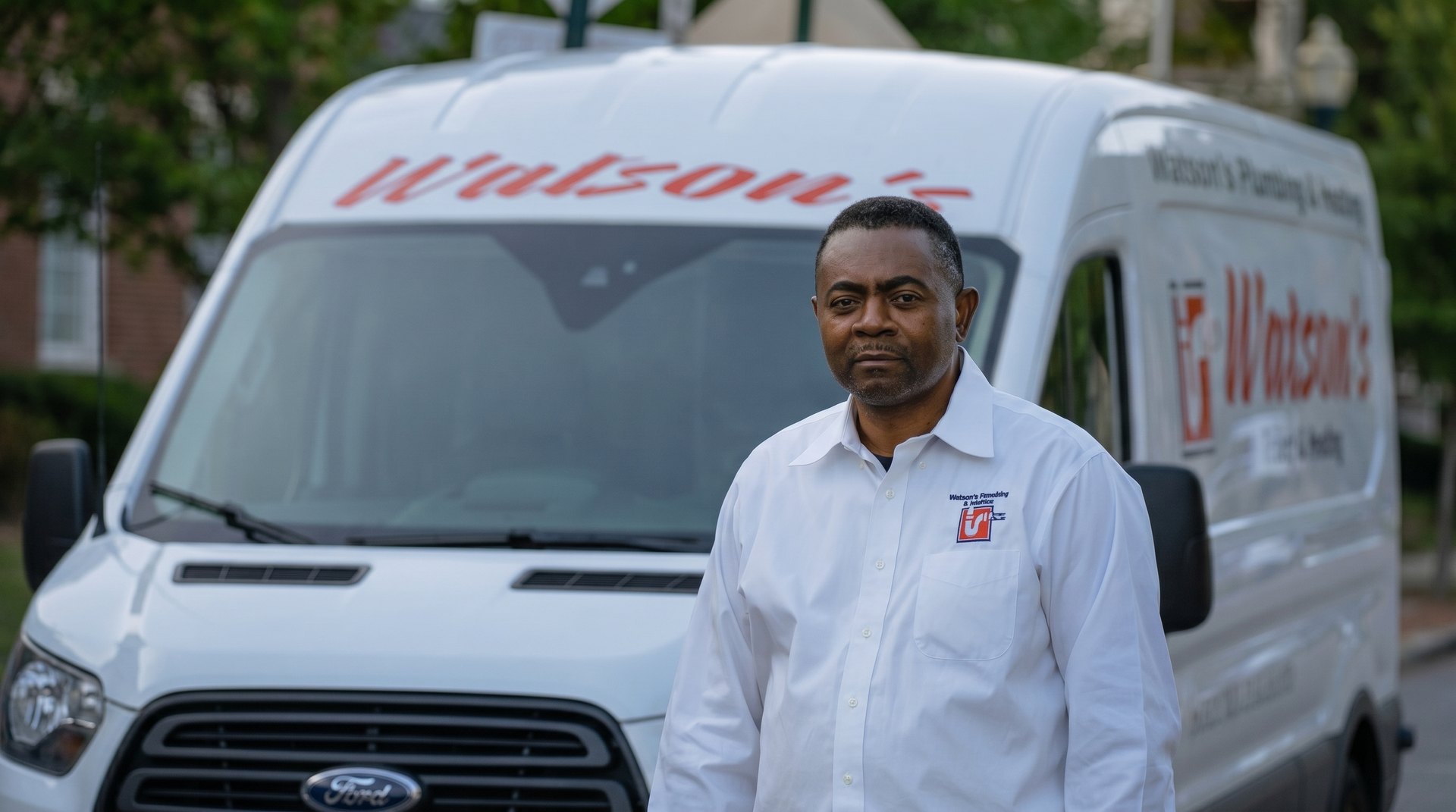 Kenroy A. Watson, founder & CEO of Watson's Plumbing, Heating & Building Services, in front of a branded Watson's van in NYC